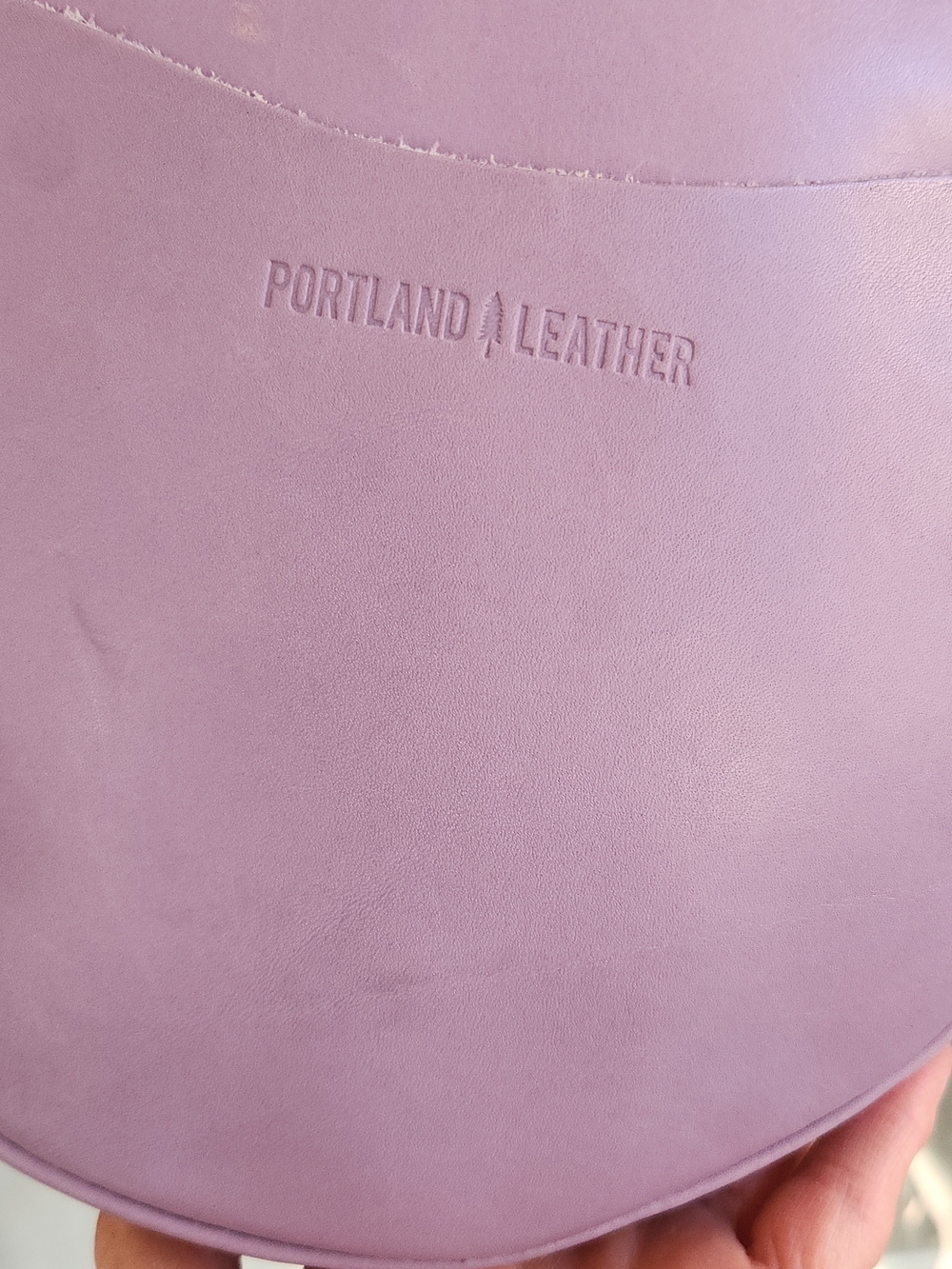 The purple round bag in the image is a Circle Crossbody in the color Lavender - Picture 2 of 8